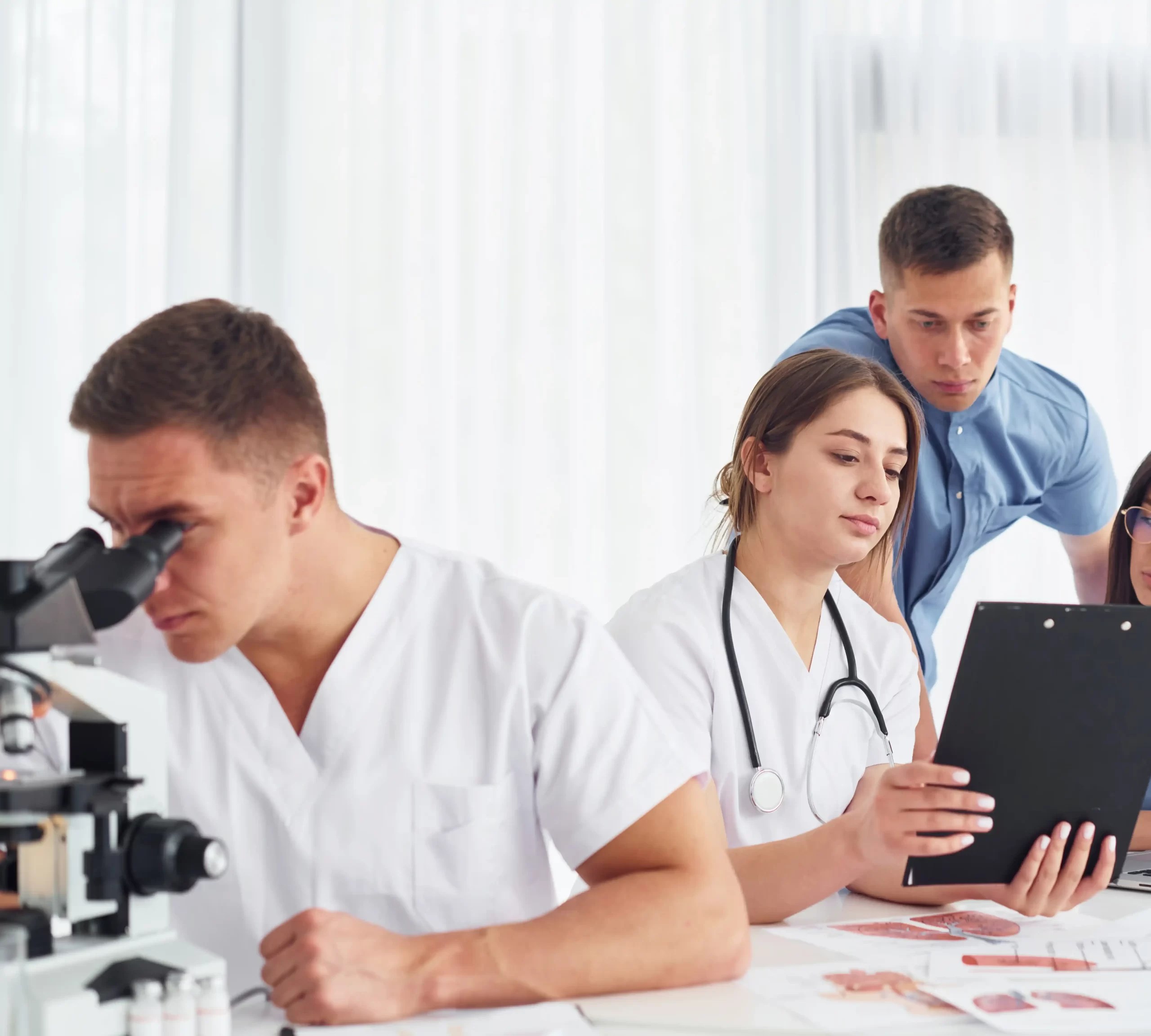 man with microscope group young doctors is working together modern office